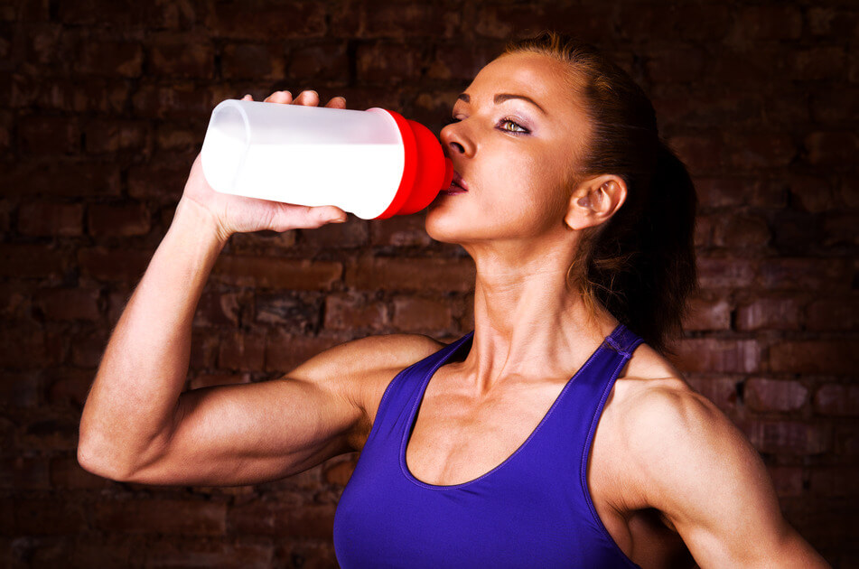 strong woman is drinking sports nutrition