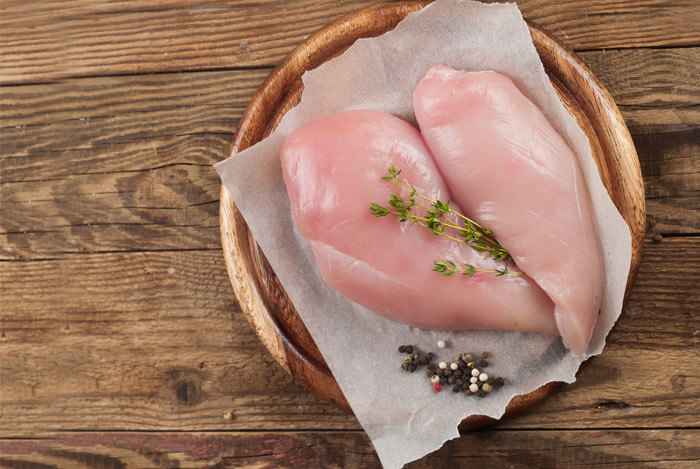 uncooked chicken breast board