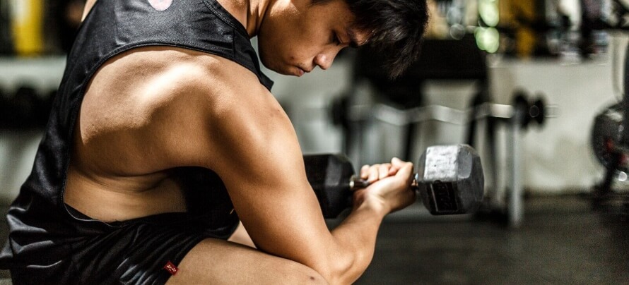 Man in Black Tank Top Doing Dumbbell Concentration Curls