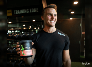 Person holding a pre-workout tub, showing that most pre workout doesn’t have creatine.