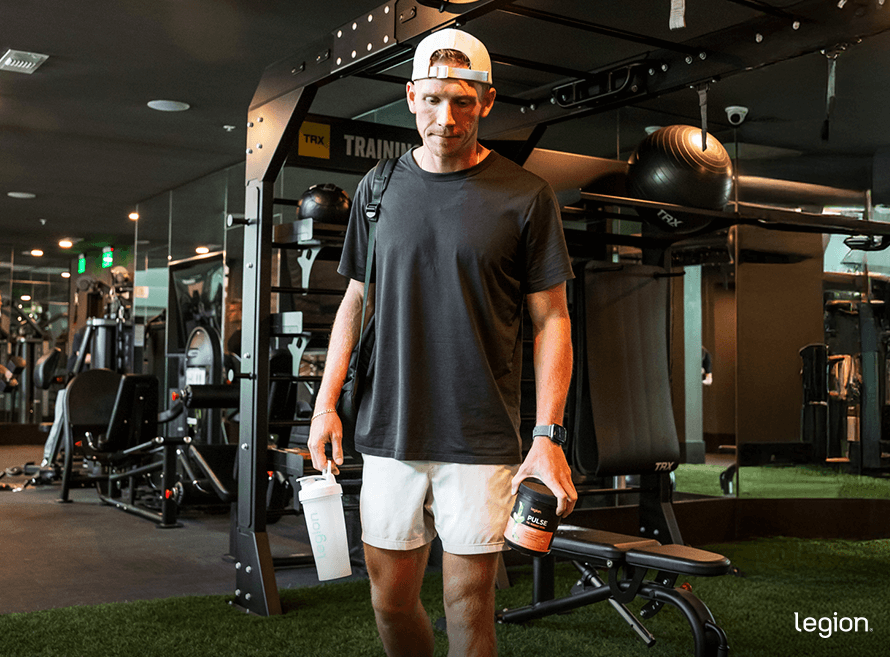 Athlete heading to train with Legion Pulse and a shaker bottle, showing the safer alternative to dry scooping pre-workout.
