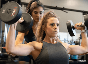 Female doing shoulder press—a great breast-lifting exercise
