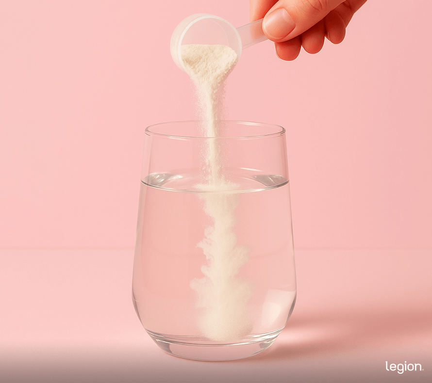 Person pouring scoop of collagen protein powder into water.