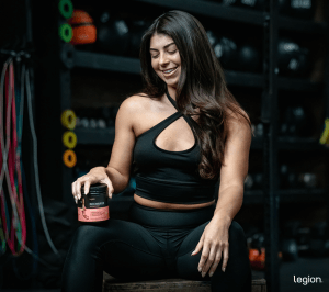 Person holding creatine, trying to understand the difference between creatine and pre workout.