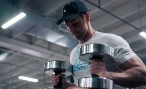 Mike Matthews setting up for the dumbbell bench press to illustrate why some people ask whether dumbbell bench press is better than barbell.
