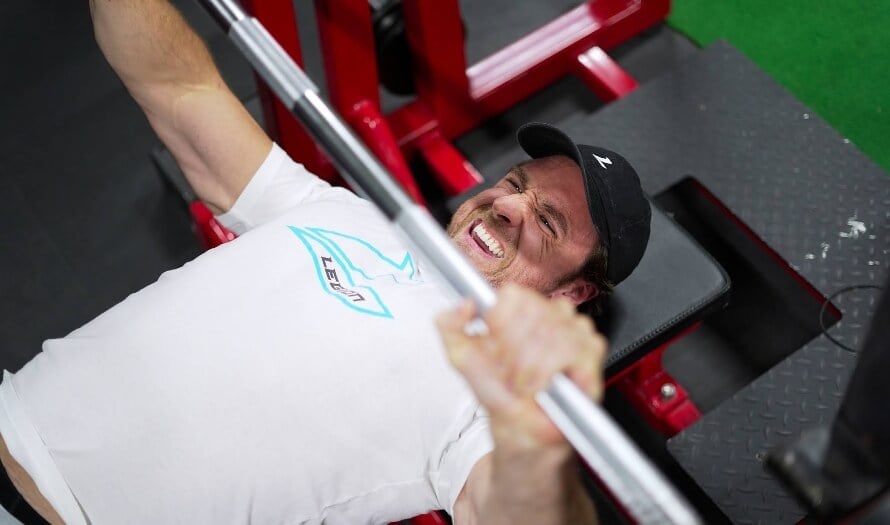 Mike Matthews doing a barbell bench press to illustrate strength differences in the bench press vs dumbbell press debate.