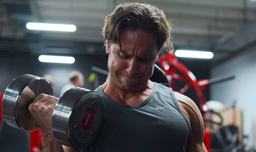 Athlete doing biceps curls, showcasing an exercise in every good back and biceps workout