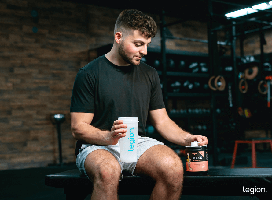 Man preparing pre-workout supplement with transparent labeling to reduce pre-workout side effects
