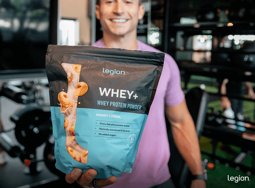 Male athlete holding protein powder, answering whether pre-workout has protein or replaces protein powder