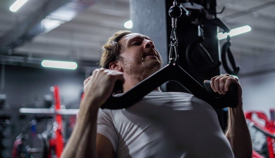 Athlete doing the lat pulldown, which is arguably the most effective back and biceps exercises.