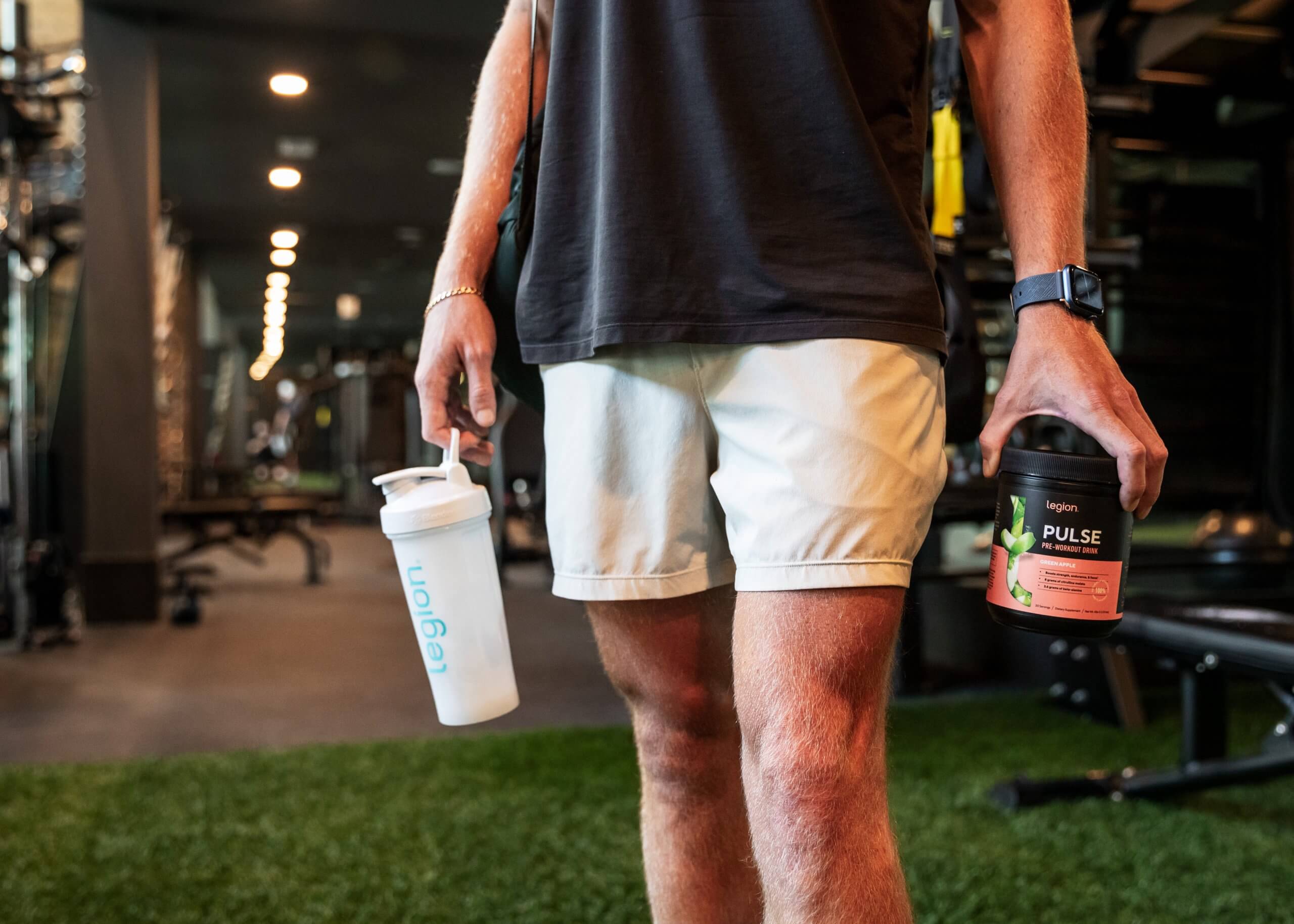 Athlete holding pre-workout supplement in gym, representing when pre-workout side effects may be a concern