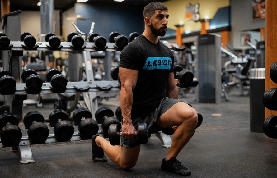 Bodybuilder performing leg workouts with dumbbells in a gym setting