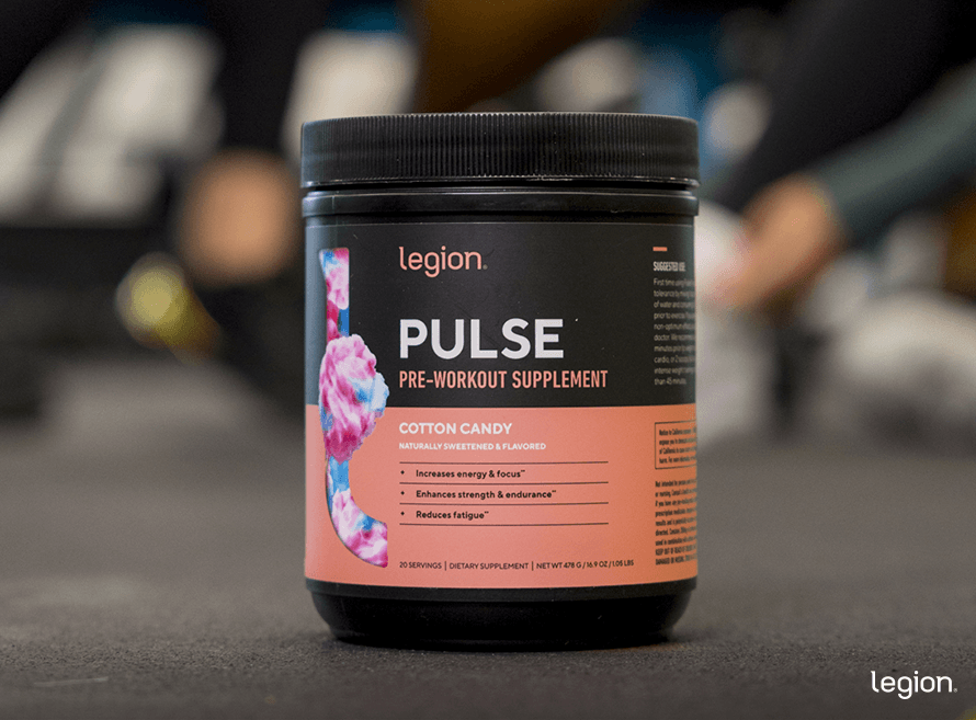 Bottle of Pulse pre-workout on the gym floor with a clear label showing how many calories in each serving.