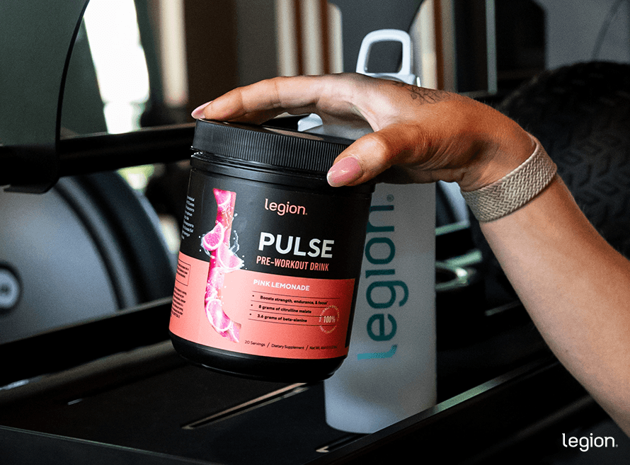 Female athlete taking pulse off a shelf to check the label. She wants to know if her pre-workout contains calories.