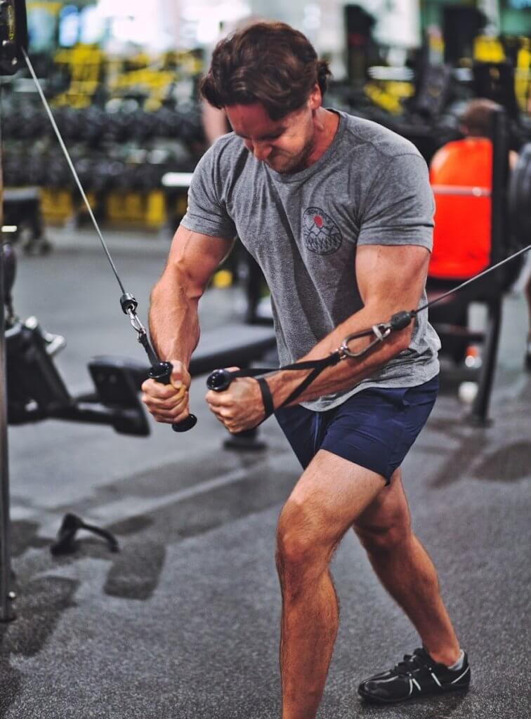 Male athlete doing cable flyes during a chest and back day.