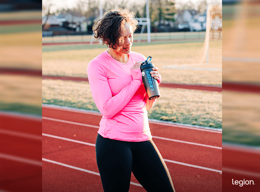 Female athlete drinking a protein shake after finishing some cardio as part of a PCOS exercise plan.