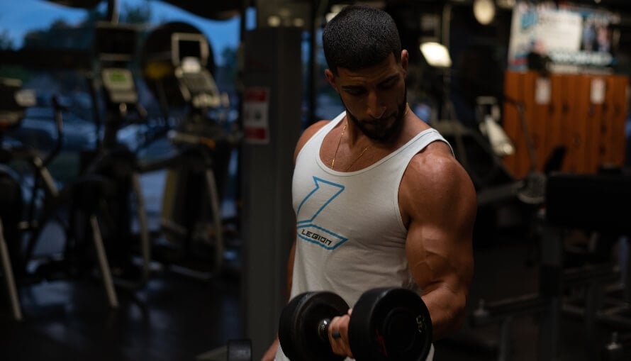 Male athlete doing biceps curls while following Lyle McDonald's Generic Bulking Routine.