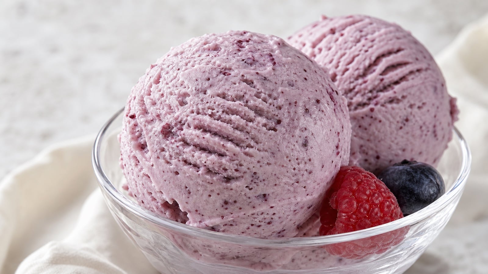 Close scoops of berry cottage cheese ice cream showing their creamy texture and berry flecks