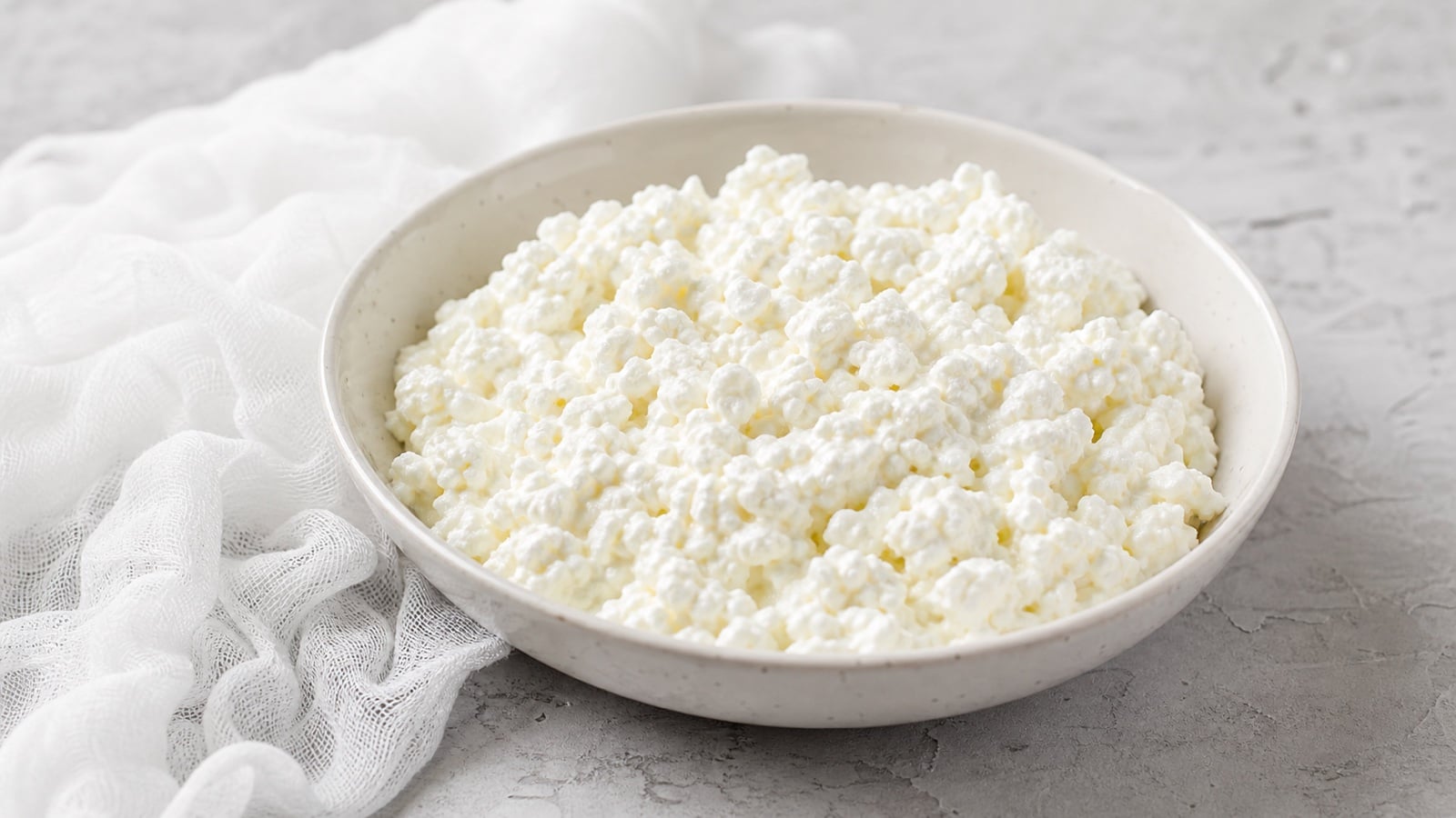 Fresh homemade cottage cheese in a shallow ceramic bowl
