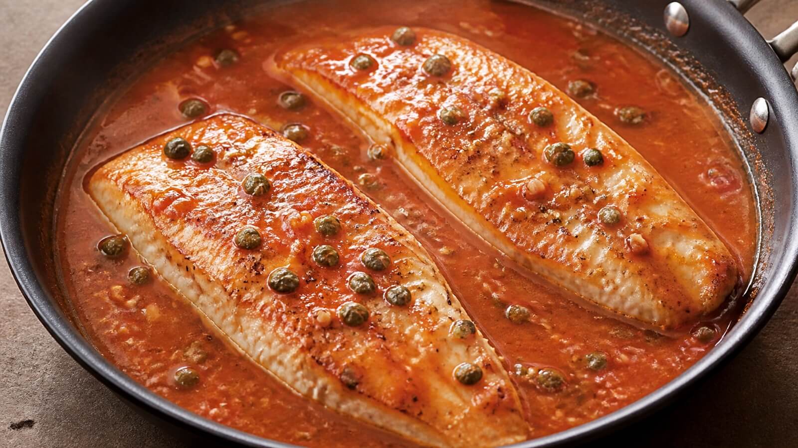 Halibut fillets in tomato, white wine, and caper sauce